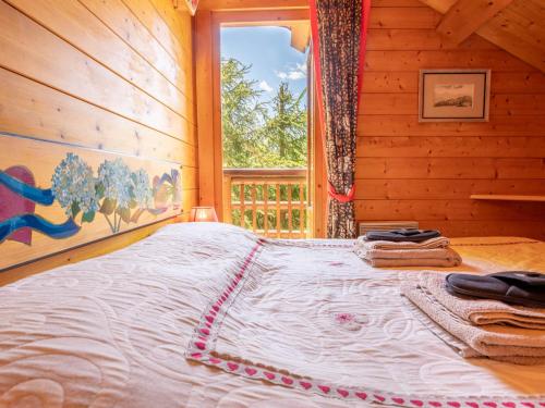 a bed in a log cabin with a window at Chalet chaleureux · Ski aux pieds · Cheminée · WIFI gratuit - FR-1-688-1 in Méribel