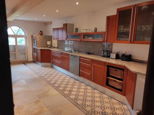 uma grande cozinha com armários de madeira e piso em azulejo em Michelshof em Kevelaer