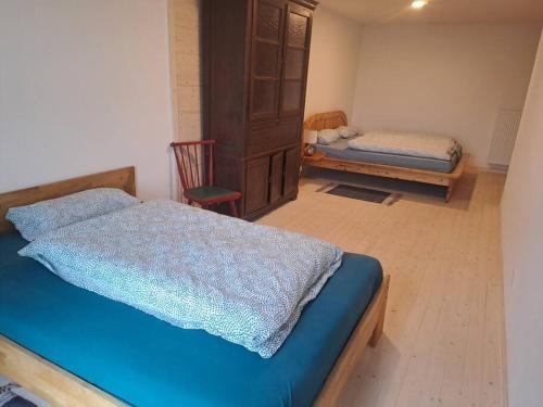 um quarto com uma cama azul e uma cadeira em Michelshof em Kevelaer