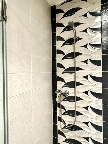 a shower in a bathroom with a black and white wall at MyCity in Rabat