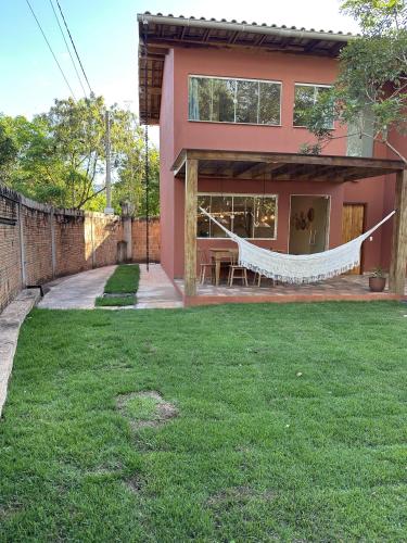 a house with a hammock in the yard at Lençóis em cantos in Lençóis