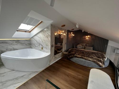 a large bathroom with a tub and a bed at Monte 27 Lux Apartments in Sopot