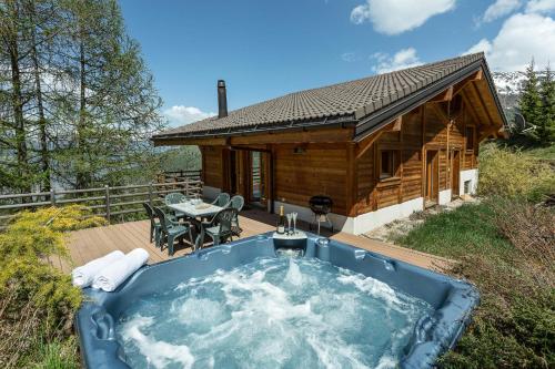 einen Whirlpool auf dem Deck einer Blockhütte in der Unterkunft Chalet Kudu in La Tzoumaz