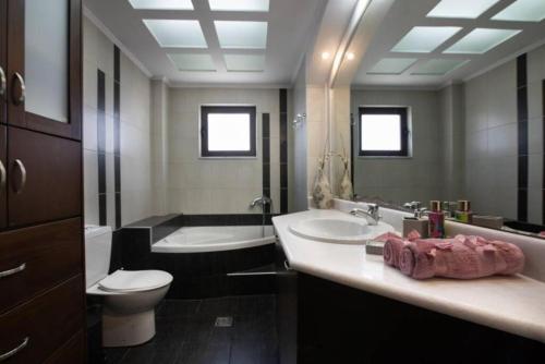 łazienka z umywalką, toaletą i wanną w obiekcie Terpsis House w mieście Kisamos