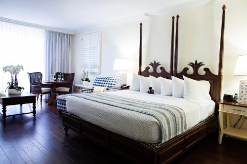 a bedroom with a large bed and a table and chairs at Inn at Pelican Bay in Naples