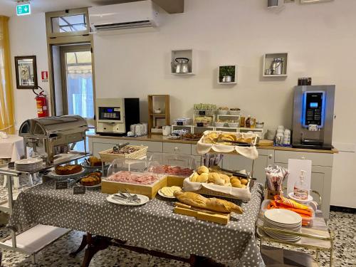 - une cuisine avec une table et de la nourriture dans l'établissement Hotel Rosa Caorle, à Caorle