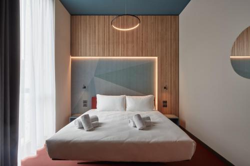 a bedroom with a large white bed with two pillows at 21 House of Stories Navigli in Milan
