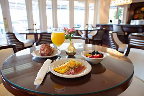 a table with breakfast foods and a glass of orange juice at Inn at Pelican Bay in Naples