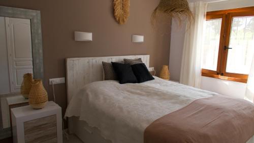 sypialnia z łóżkiem z czarnymi poduszkami i oknem w obiekcie Villa Sal y Mar - Jávea ! Freshly Renovated ! w mieście Jávea