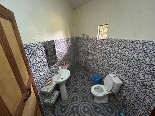 a bathroom with a toilet and a sink at Complete House in the jungle, near the sea. in Kafountine