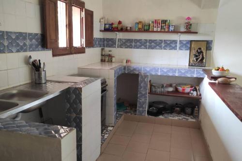 a kitchen with a fireplace in the middle of it at Complete House in the jungle, near the sea. in Kafountine
