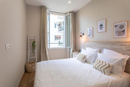 una camera da letto con un grande letto bianco e una finestra di L19 1BDR Massena central 2mins Sea/PromenadeAC/Balcony a Nizza