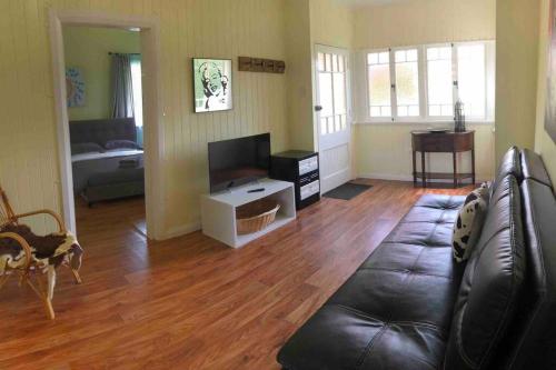 a living room with a couch and a television at Queenslander in the heart of Atherton - Spotless in Atherton