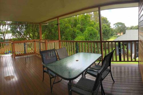 a deck with a table and chairs on a porch at Queenslander in the heart of Atherton - Spotless in Atherton