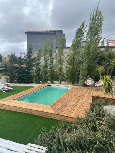 a swimming pool with a wooden deck and a swimming poolvisor at Casa da Nogueira in Arcos