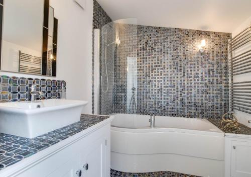 a white bathroom with a tub and a sink at 42 Seaview Road in Reydon