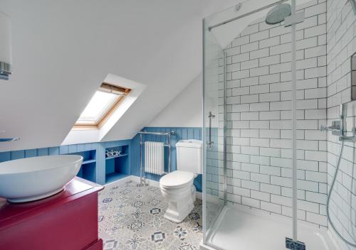 a bathroom with a toilet and a glass shower at 5 River Lane in Halesworth