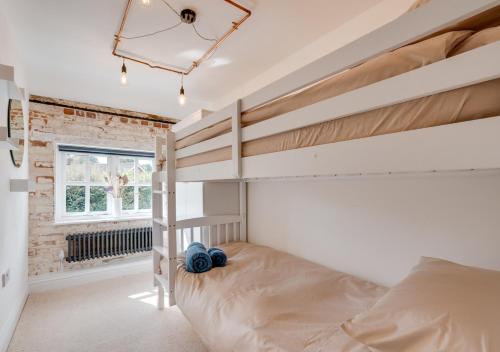 a bedroom with a bunk bed and a window at 5 River Lane in Halesworth