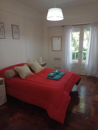 - une chambre avec un lit rouge et une couverture rouge dans l'établissement Arenas MDQ, à Mar del Plata