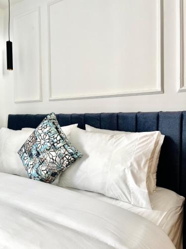 a bed with white pillows and a blue headboard at MyCity in Rabat