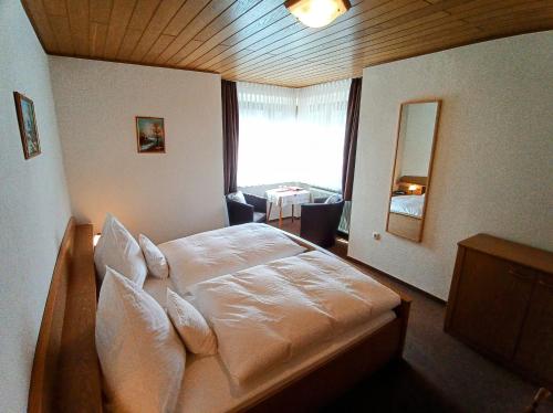 1 dormitorio con 1 cama grande y ventana grande en Pension Milberg Assmannshausen, en Rüdesheim am Rhein