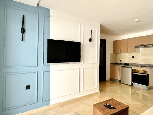 a kitchen with white cabinets and a flat screen tv at MyCity in Rabat
