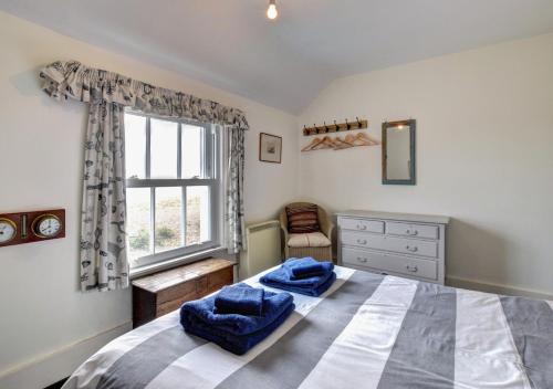 Un dormitorio con una cama grande y una ventana en 6 Coastguard Cottages en Hollesley