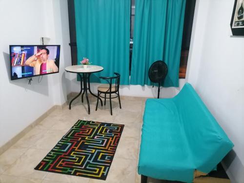 a living room with a blue couch and a table at B1-Departamento Bolognesi in Chiclayo