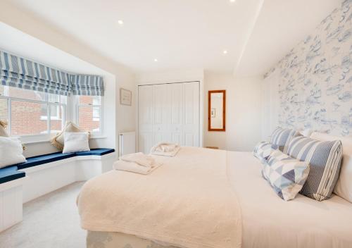 a white bedroom with a large bed and a window at 9 King Street in Aldeburgh