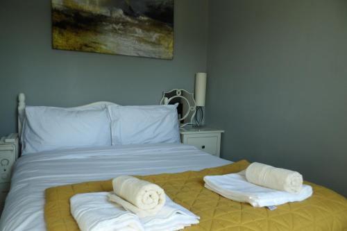 une chambre avec un lit avec des serviettes dessus dans l'établissement Aigas Cottage, à Glasgow