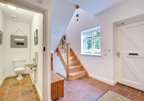 a bathroom with a toilet and a staircase in a house at Amrose Cottage in Blythburgh