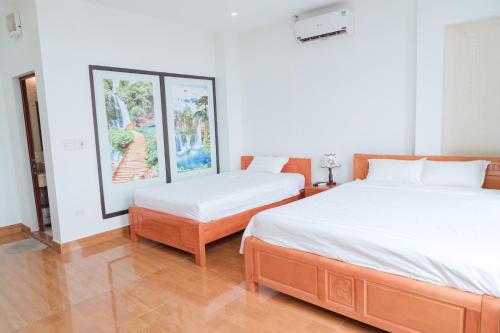 2 camas en una habitación con pinturas en la pared en Luxury Airport Hotel Travel, en Noi Bai