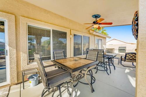 a patio with a table and chairs and a ceiling fan at Palm Valley Oasis in Goodyear