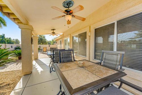a patio with a table and a ceiling fan at Palm Valley Oasis in Goodyear