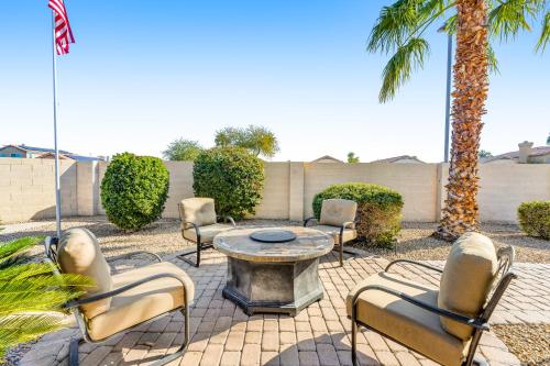 a patio with a table and chairs and palm trees at Palm Valley Oasis in Goodyear