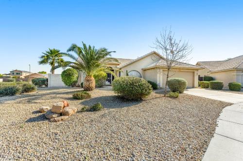 a home with a gravel driveway with trees and bushes at Palm Valley Oasis in Goodyear
