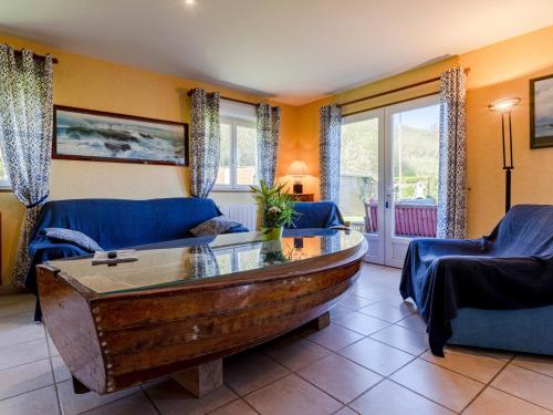 - un salon avec une table basse en bois et des chaises bleues dans l'établissement Holiday Home Chez Laurette - SNT401 by Interhome, à Saint-Laurent-sur-Mer