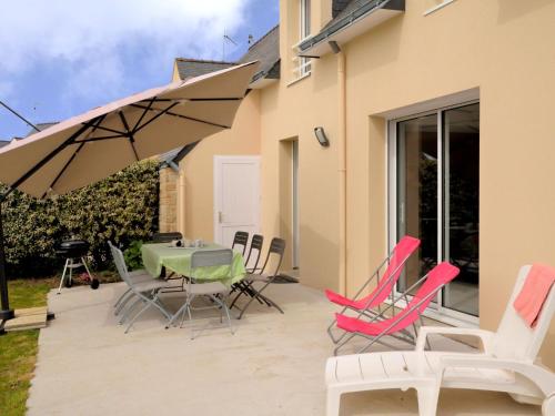 eine Terrasse mit einem Tisch, Stühlen und einem Sonnenschirm in der Unterkunft Holiday Home Les Volets Bleus - LTB307 by Interhome in La Turballe