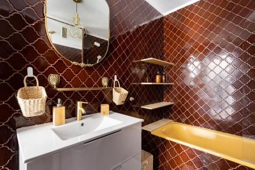 een badkamer met een wastafel, een spiegel en een bad bij EDEN RENTALS Kings Kapital in Santa Cruz de Tenerife