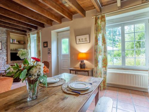 a living room with a wooden table with a vase of flowers at Holiday Home La Haute Gilberdière - SIY400 by Interhome in Sartilly