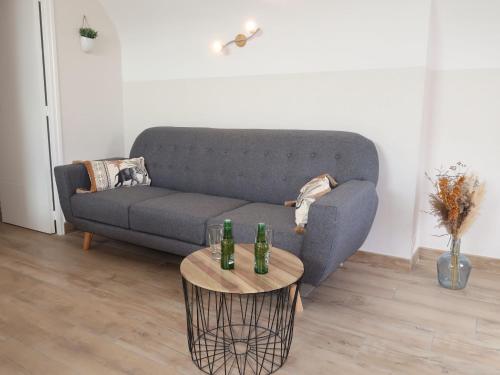 - un salon avec un canapé et 2 bouteilles sur une table dans l'établissement Holiday Home Hoedic by Interhome, à Plouhinec