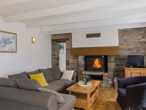 un salon avec un canapé et une cheminée dans l'établissement Holiday Home Ty Coz ar Mor by Interhome, à Portsall