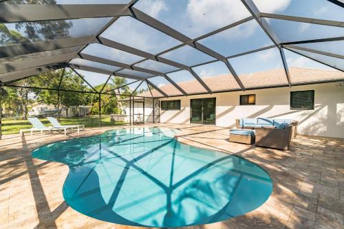 a large swimming pool with a glass roof at Indies Pool Paradise in Jupiter