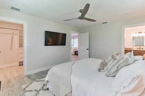 a white bedroom with a bed and a ceiling fan at Indies Pool Paradise in Jupiter