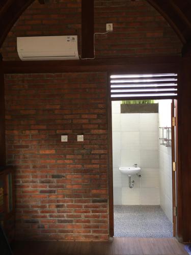 a bathroom with a brick wall and a sink at Kubu Pering in Keramas