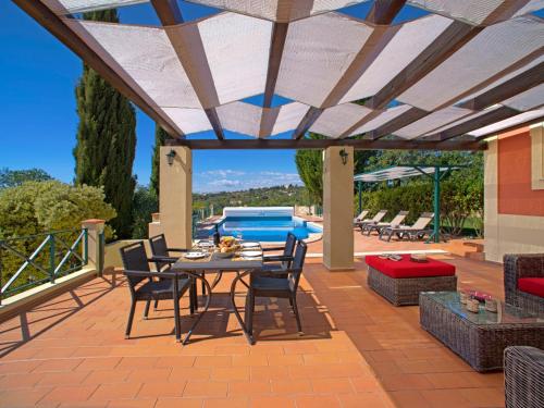 a patio with a table and chairs and a pool at Holiday Home Montinho by Interhome in Loulé