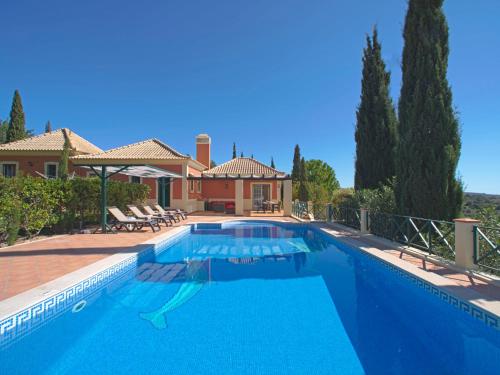 a swimming pool in front of a house at Holiday Home Montinho by Interhome in Loulé