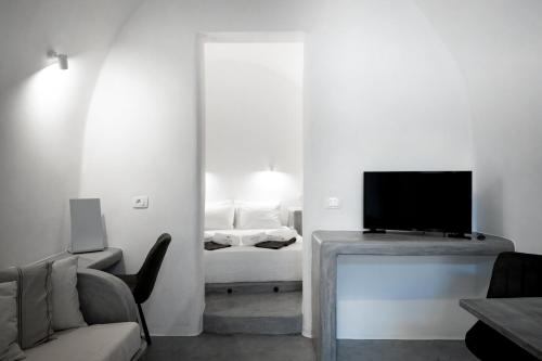 a living room with a couch and a television at Lotza Studios in Oia