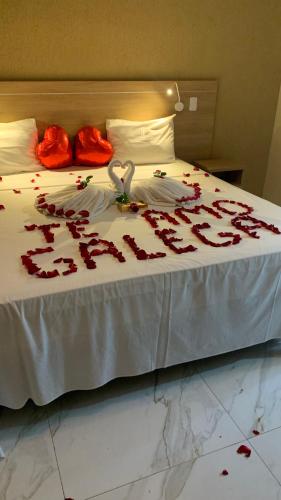 a bed with red rose petals on it at Pousada Piri Paim in Pirenópolis