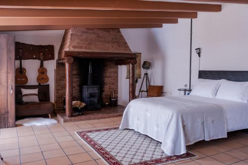 a bedroom with a bed and a brick fireplace at Casa do Lume in Leiria